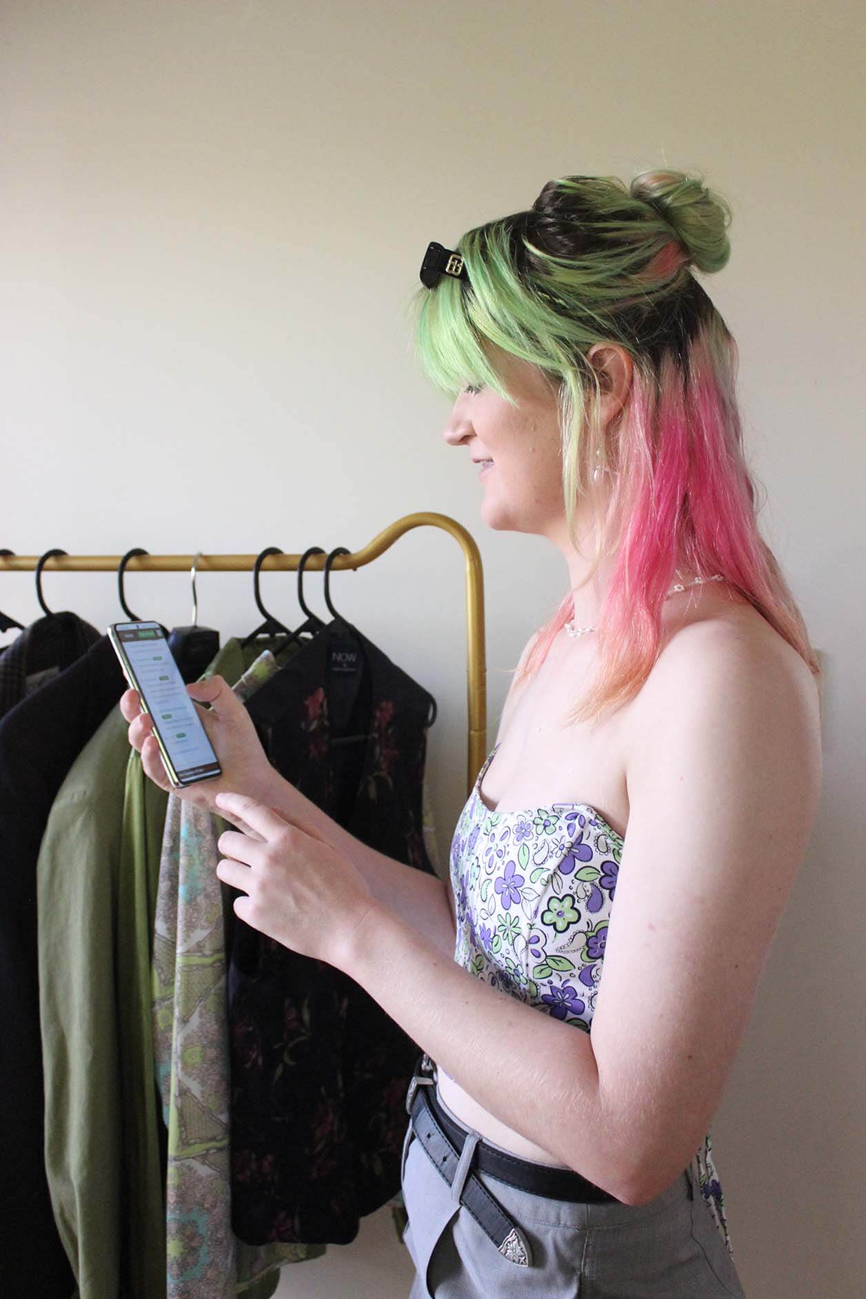 girl with phone and clothing racks